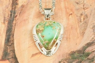 Genuine Royston Turquoise set in Sterling Silver Pendant. Beautiful Turquoise Stone. Created by Navajo Artist Phillip Sanchez. Signed by the artist. Royston Turquoise Mine was originally known as the Royal Blue Mine. It produces Turquoise that has a mixture of blues and greens in the same formation. The Royston Turquoise Mine is located in Nye County, Nevada. Free 18 inch Sterling Silver Chain with purchase of pendant.